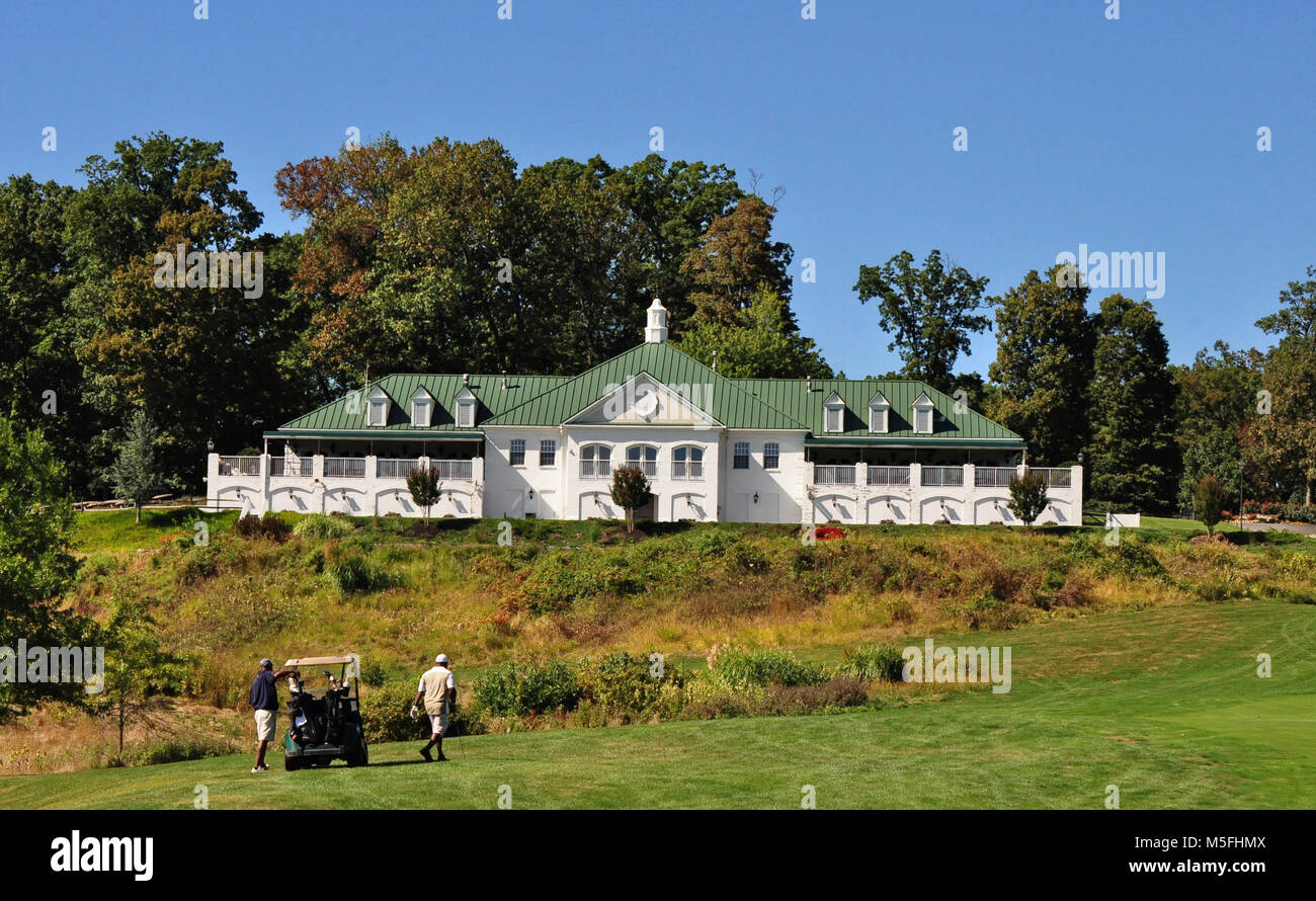 Golf twosome playing 9th hole at Greystone Golf course in Whitehall Maryland with clubhouse in background Stock Photo