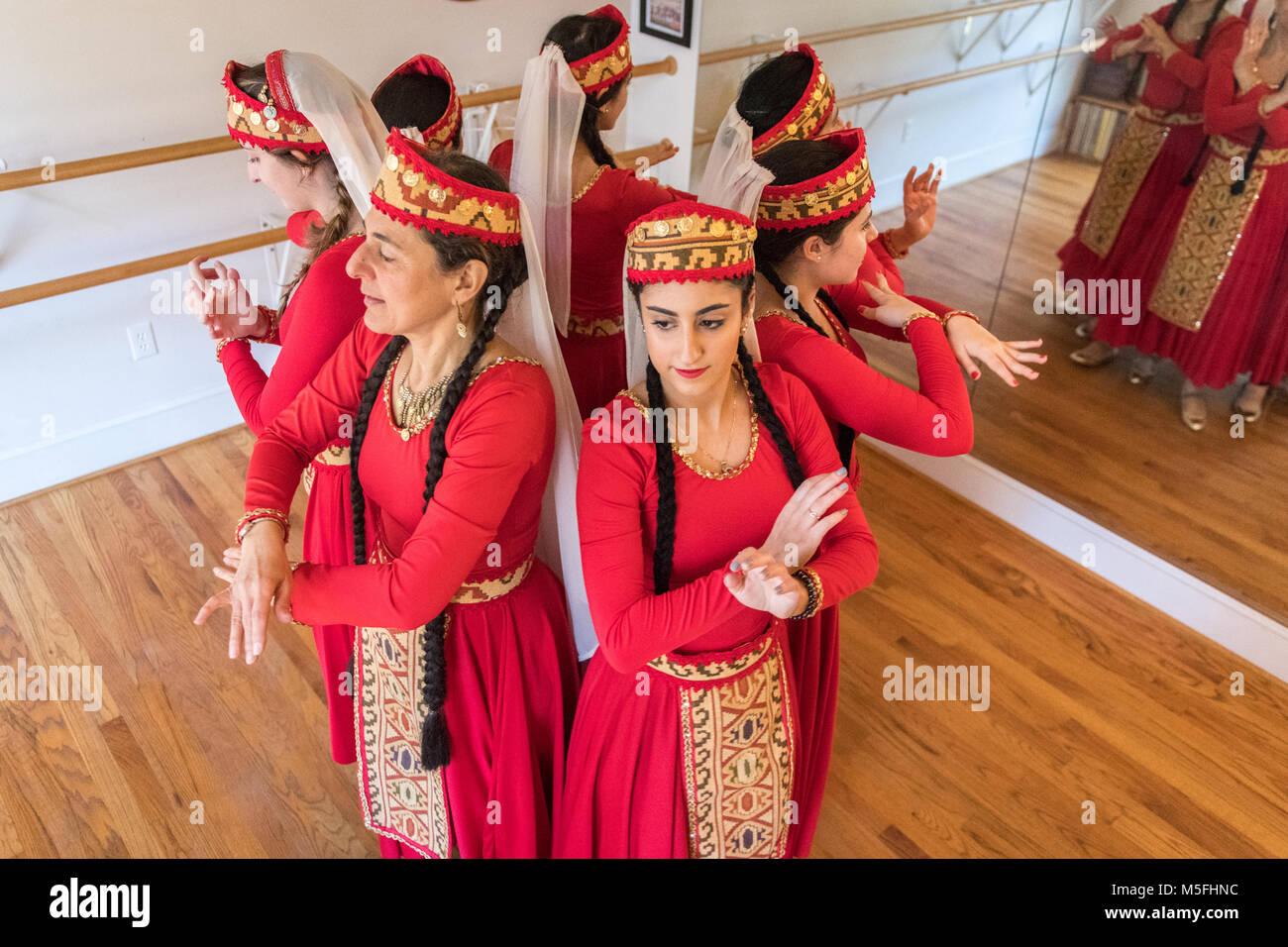 Group of female Armenian dancers coming together in a huddle in dance studio, Washington Grove, Maryland. Stock Photo