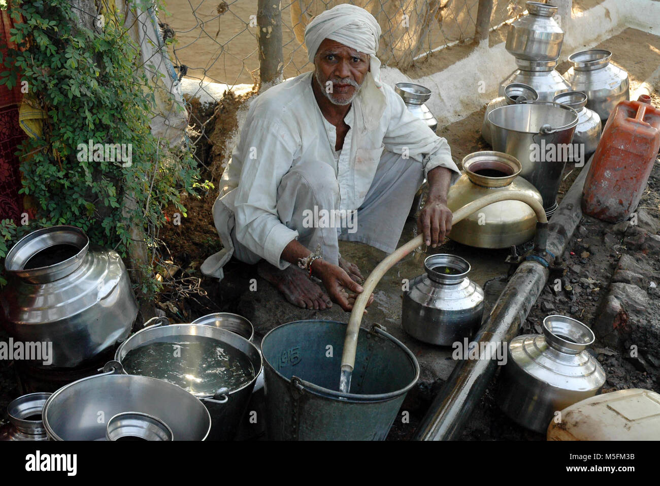 man Filling Bucket Of Water, bhopal, madhya pradesh, India, Asia Stock Photo