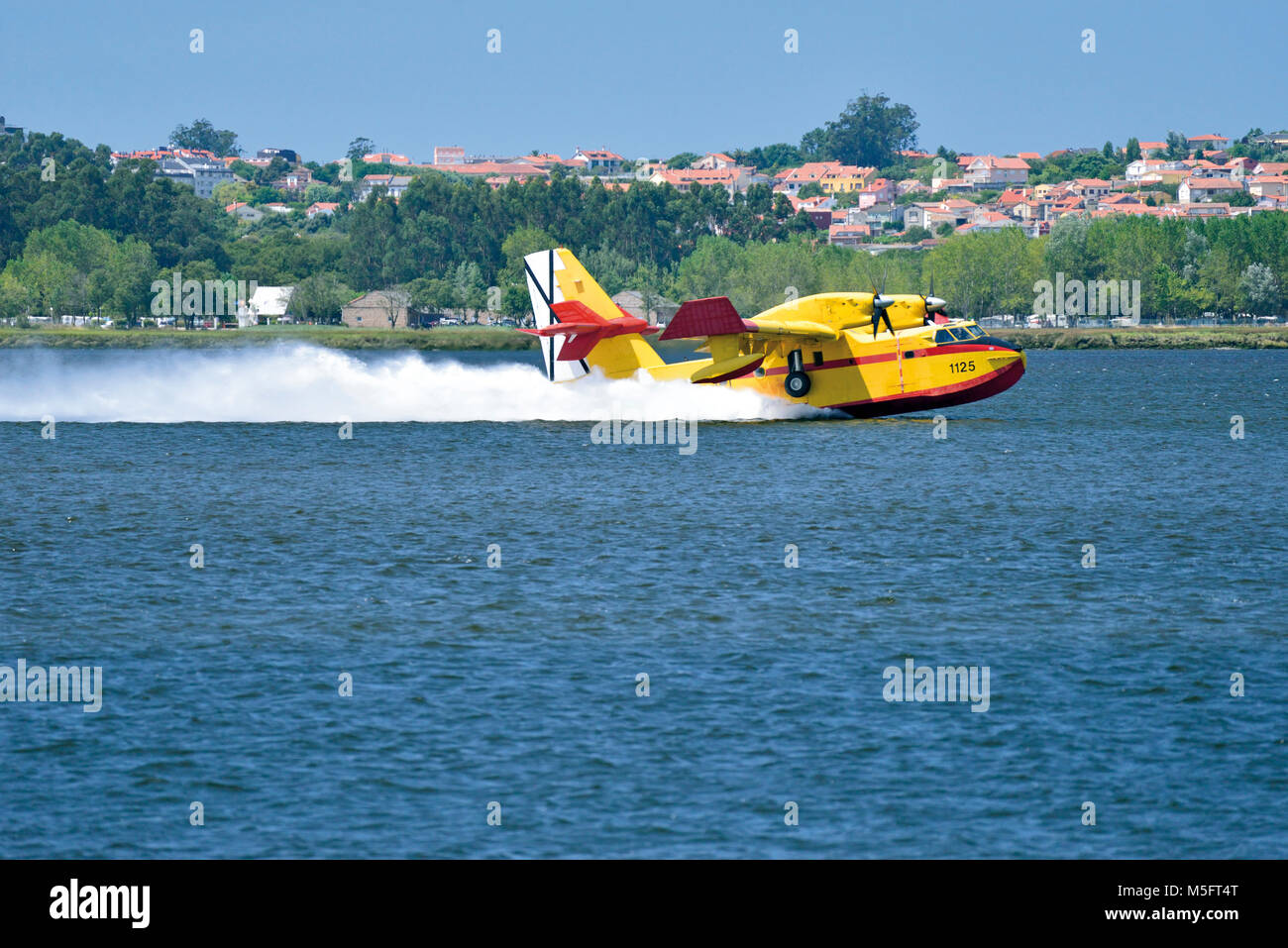 Fire-fighting plane catching water in a barrage Stock Photo