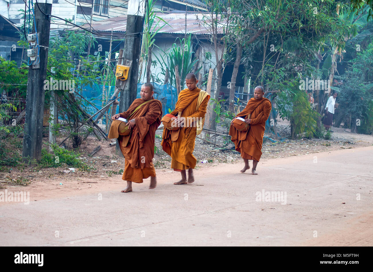 SAKON NAKHON, THAILAND, FEBRUARY, 15, 2017 - Monks walk in the early morning in the Isan village in Sakon Nakhon province, Thailand Stock Photo