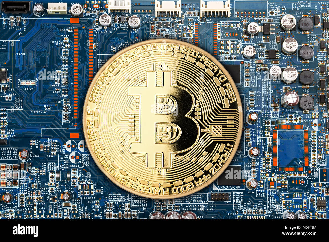 bitcoin golden coin on blue motherboard chip digital mining computer hardwarecrypto currency financial background concept Stock Photo