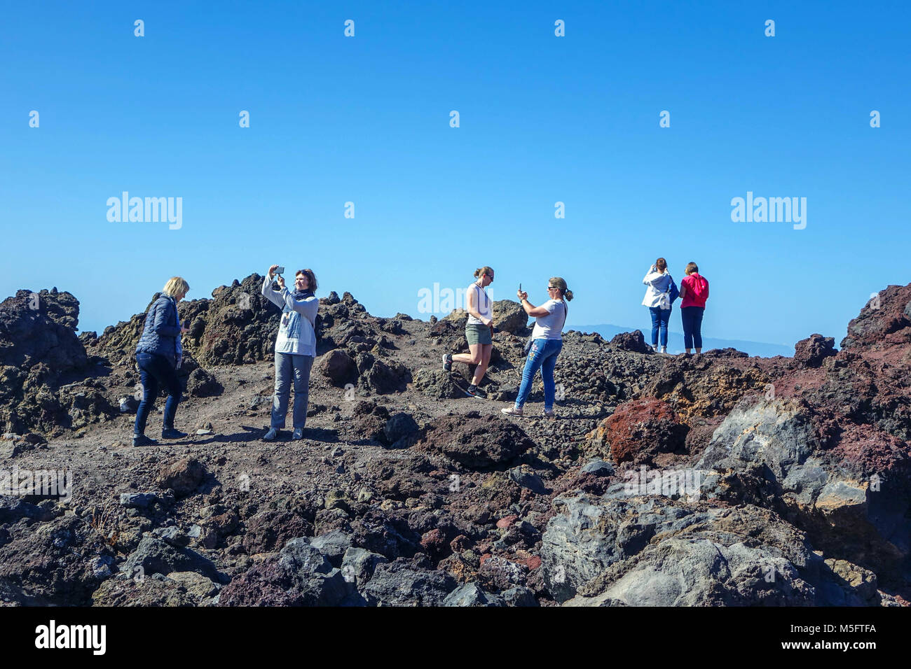 Tourists on Tenerife taking photographs and selfies with mobile phone, El Tiede, National Park Stock Photo