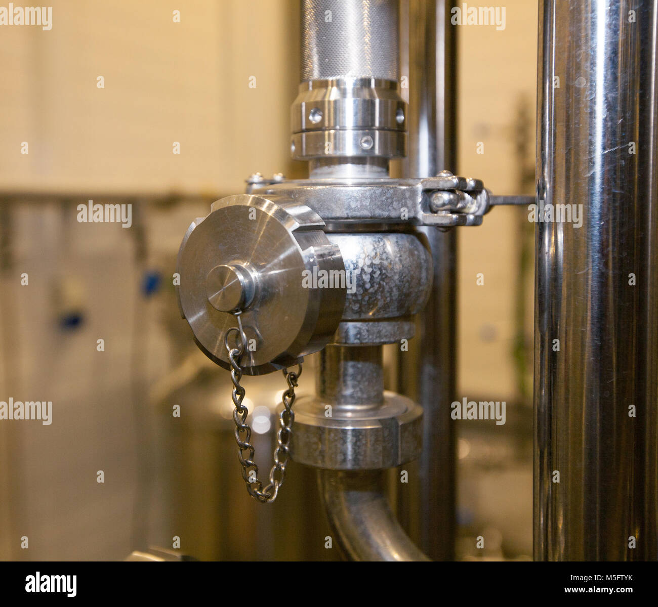Valves and pipes made of white metal, located on the tanks, which brewed beer in the brewery