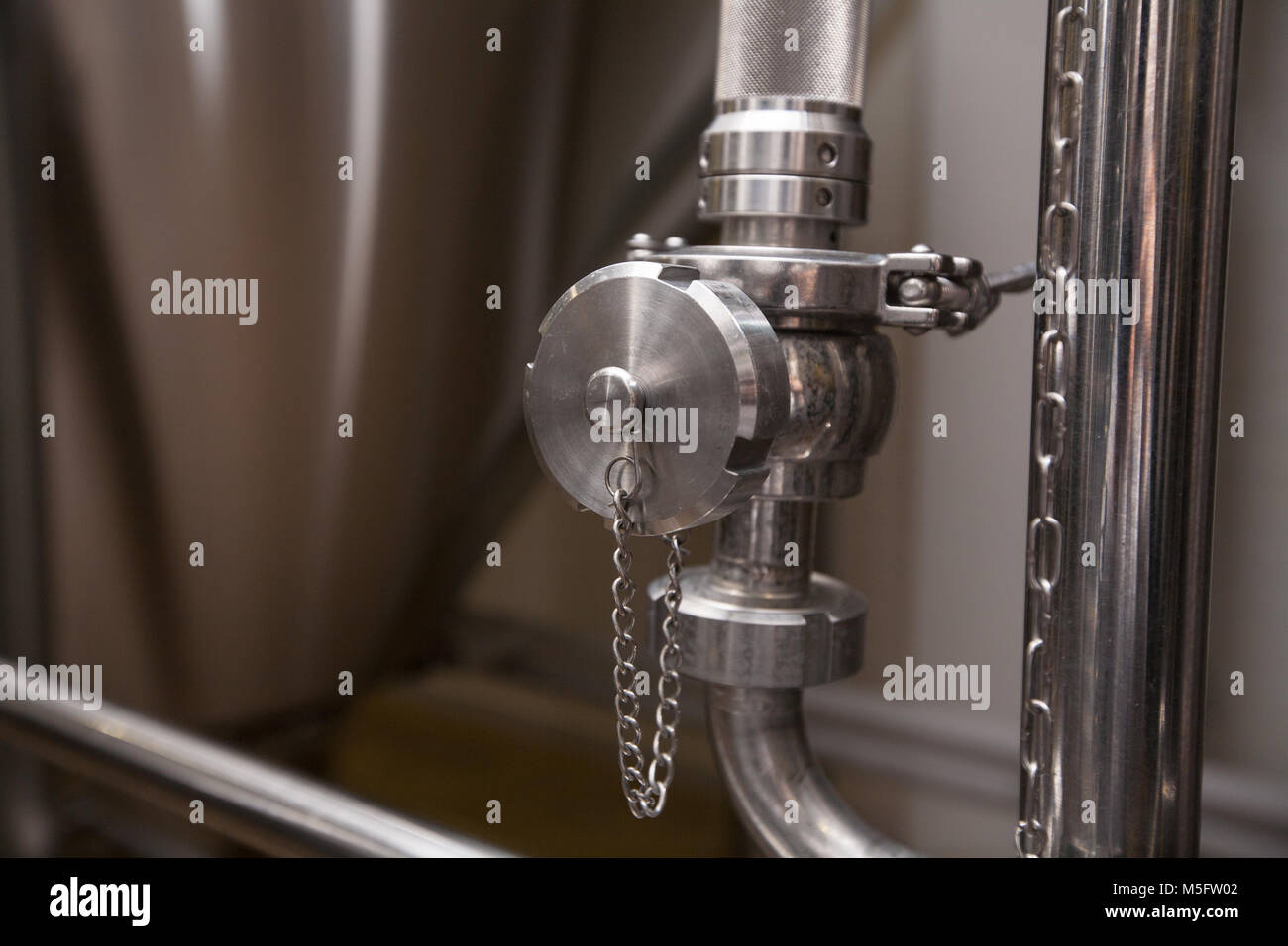 Valves and pipes made of white metal, located on the tanks, which brewed beer in the brewery