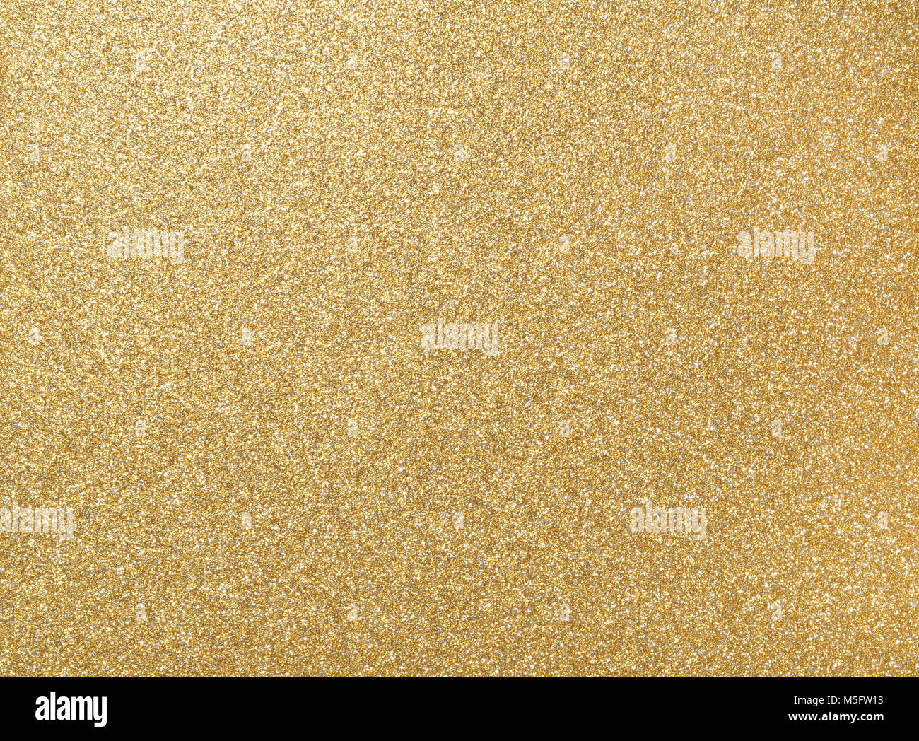 Glitter grain of gold on rough golden plate, closeup photo on rough golden plate surface show a detail of gold glister texture on gold plate, golden b Stock Photo