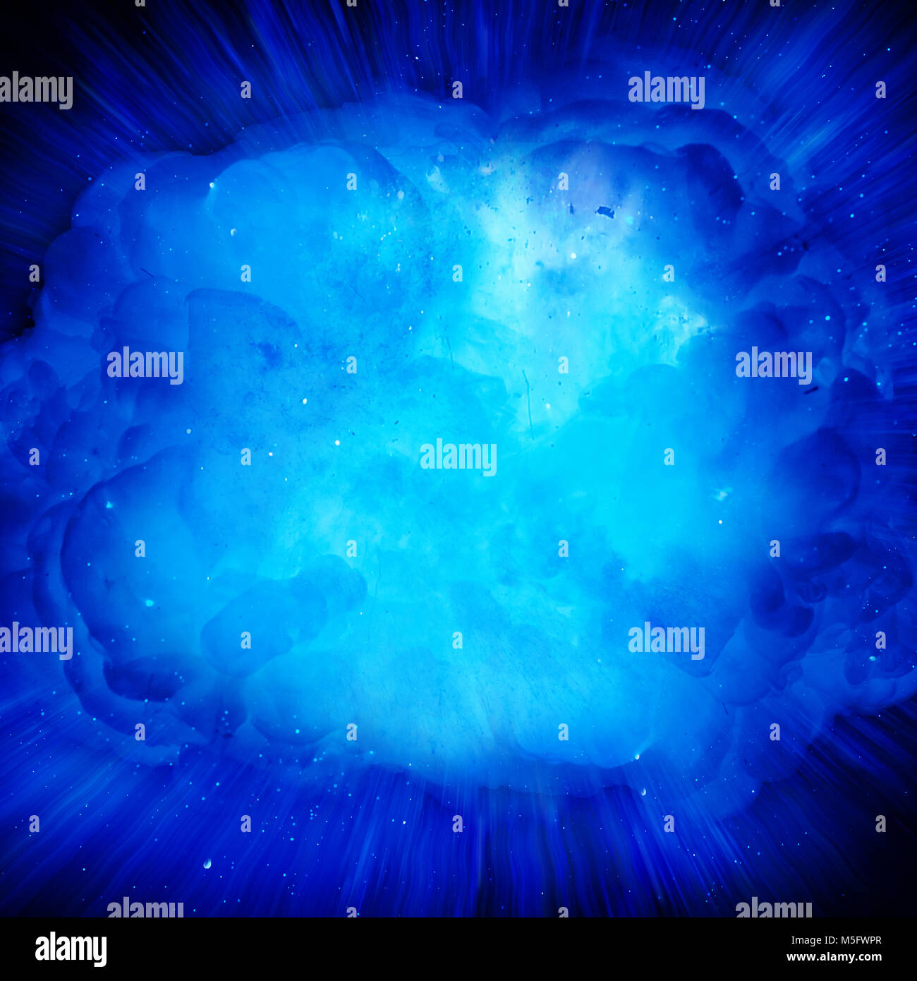 Blue fire explosion with sparks and smoke against black background Stock Photo