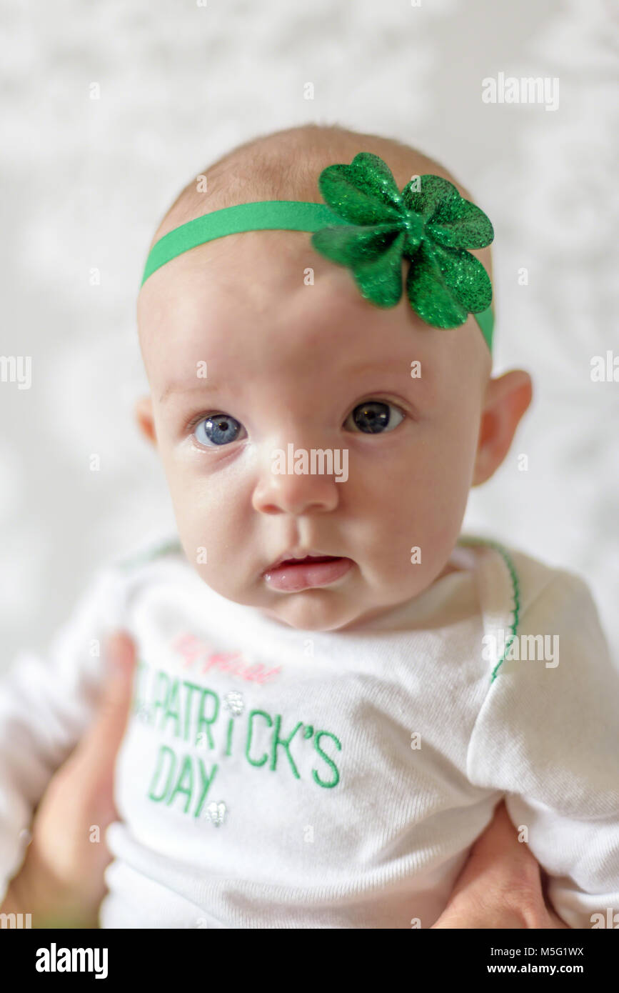 Irish baby with big blue eyes wearing St Patricks Day outfit and shamrock headband Stock Photo