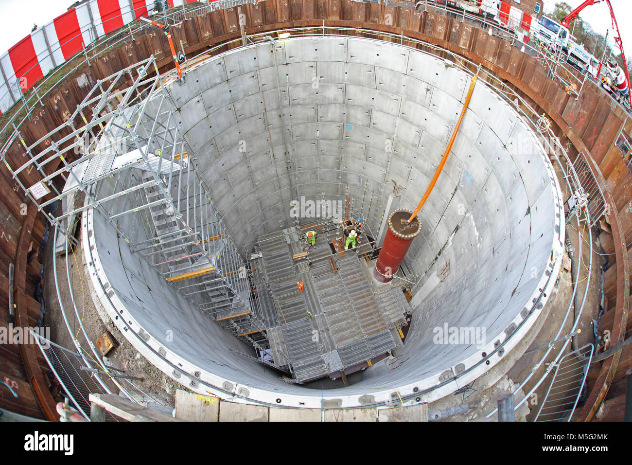 A large, circular shaft under construction as part of a major new storm drain project in Manchester, UK. Shows scaffolding and temporary staircase. Stock Photo