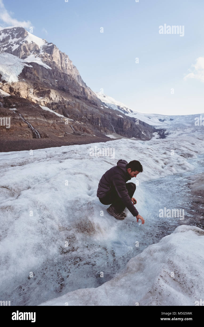 Man filling water in bottle from stream Stock Photo