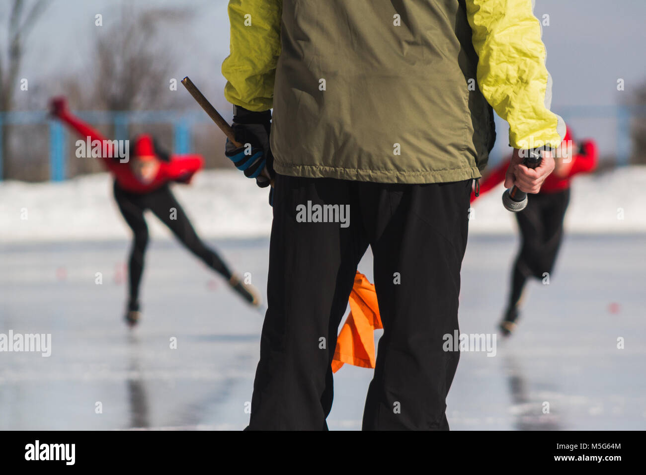 Speed skating competition instructor and sportsmen on ice rink