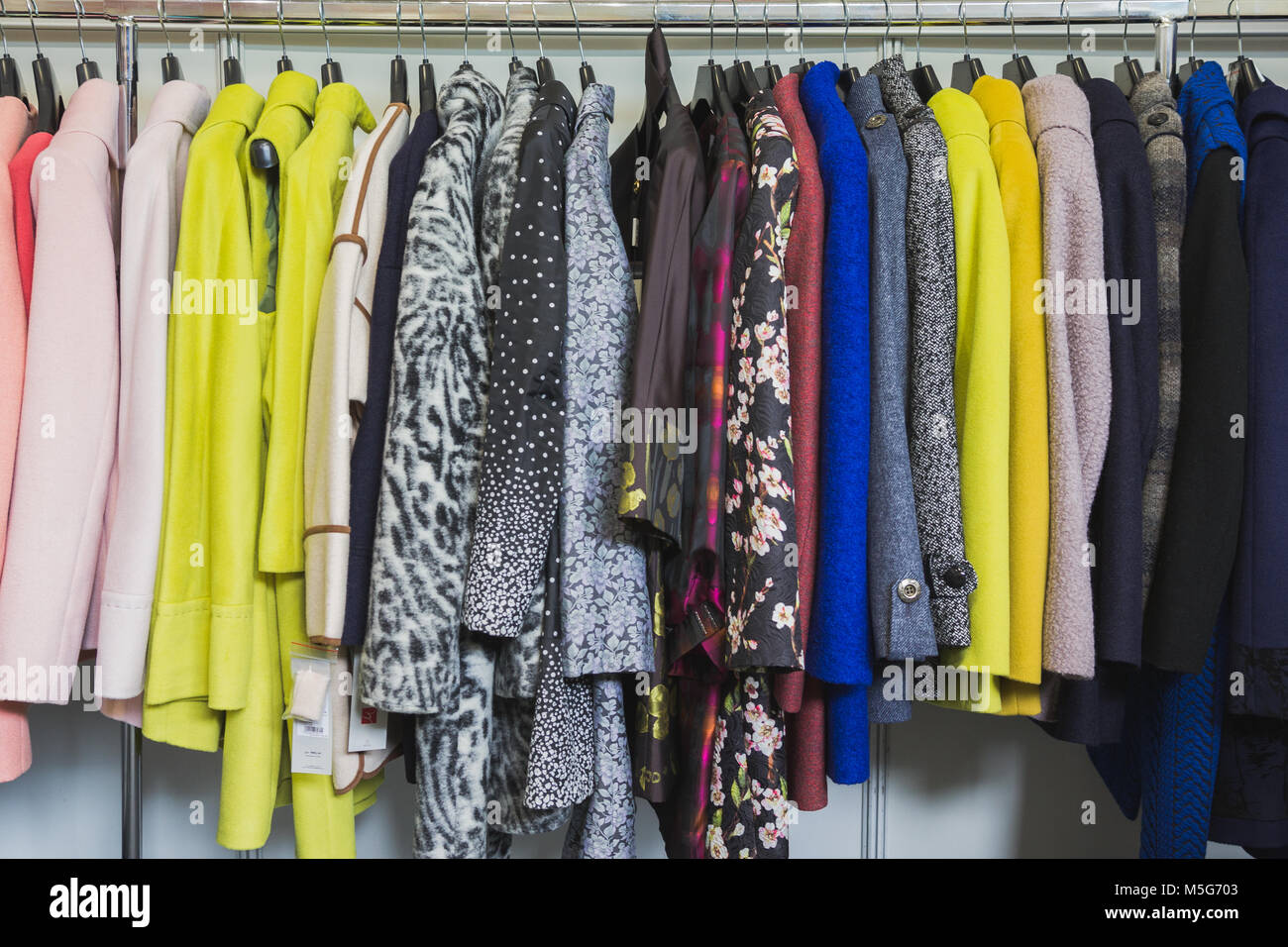 Colourful clothes in clothing store - dresses and jackets Stock Photo