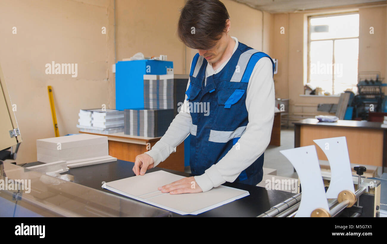 The operator of the printing house works at the typographical machine ...