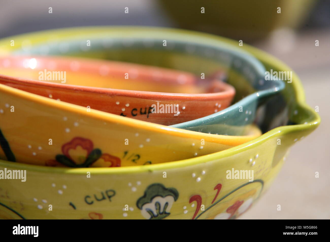 Stack of colourful decorated ceramic measuring cups Stock Photo