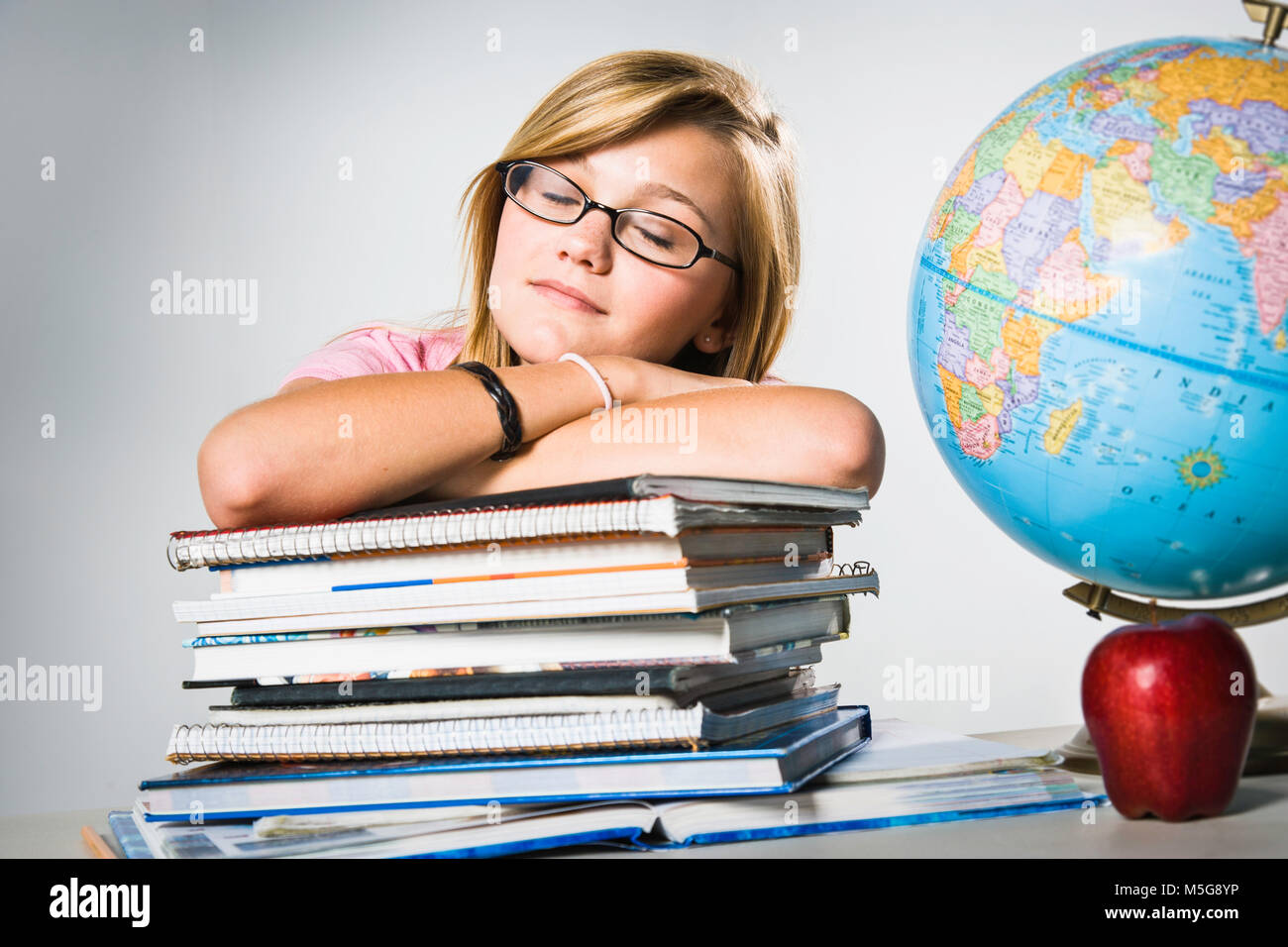Teenage girl sleeping on stack of books Stock Photo - Alamy