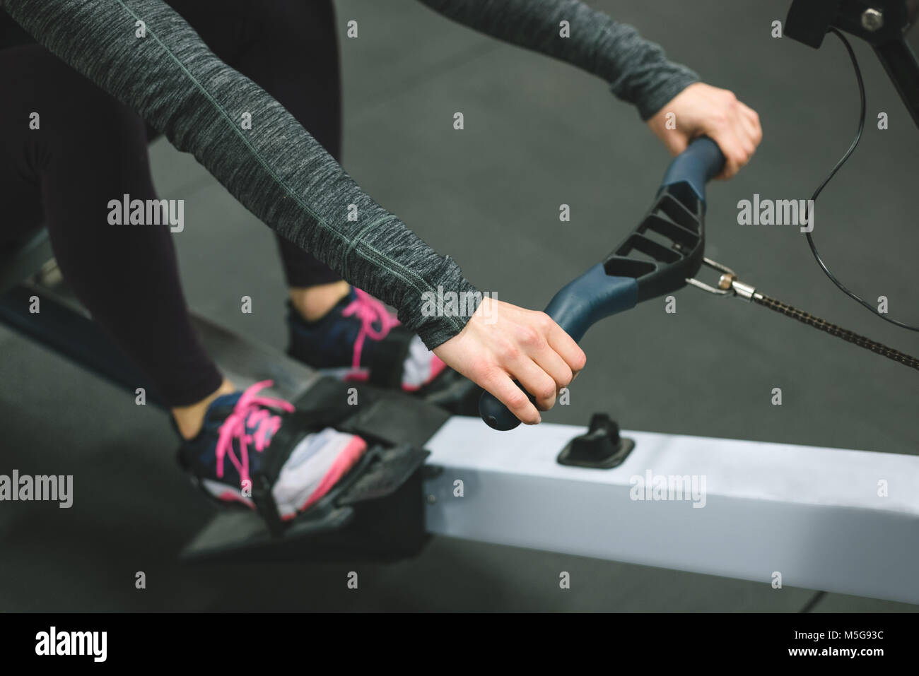 Muscular woman exercising on rowing machine Stock Photo