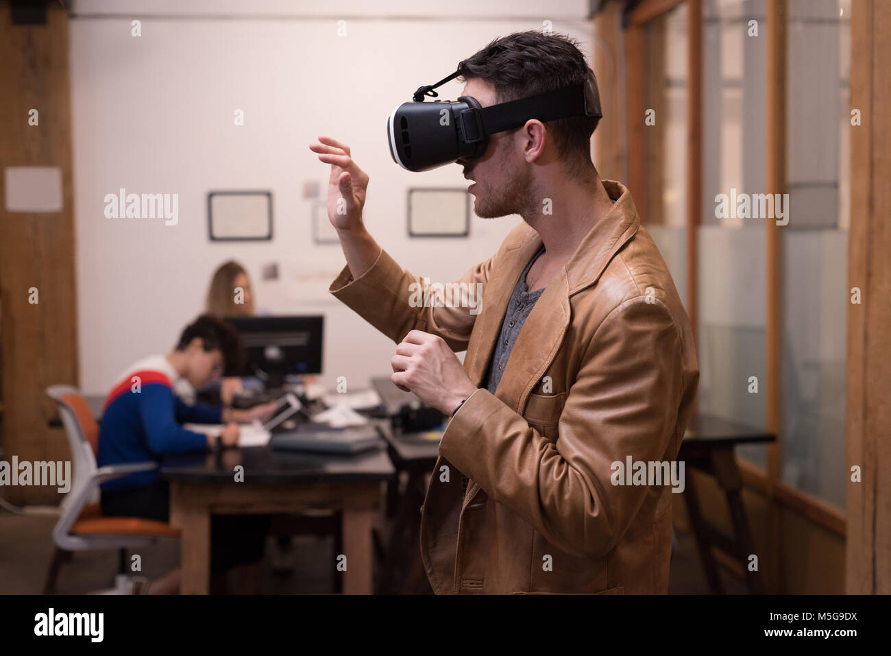 Male executive using virtual reality headset Stock Photo - Alamy
