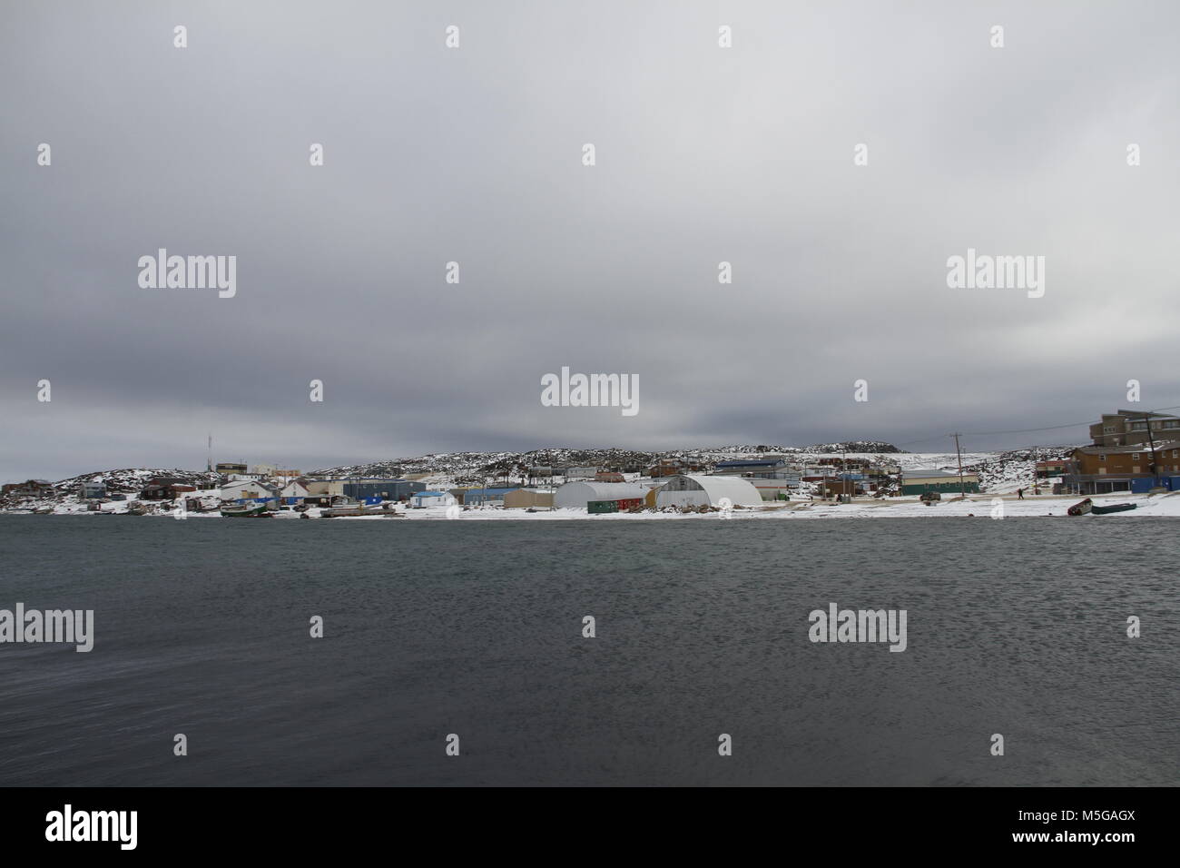 View of Cape Dorset (Kinngait) Nunavut, a northern Inuit community in arctic Canada with the ocean in the foreground Stock Photo