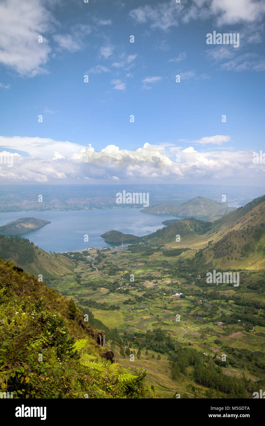 Aerial view of Ancient volcanic crater lake of Lake Toba in Sumatra, Indonesia. Majestic distant view of lake, villages and tropical green landscape Stock Photo