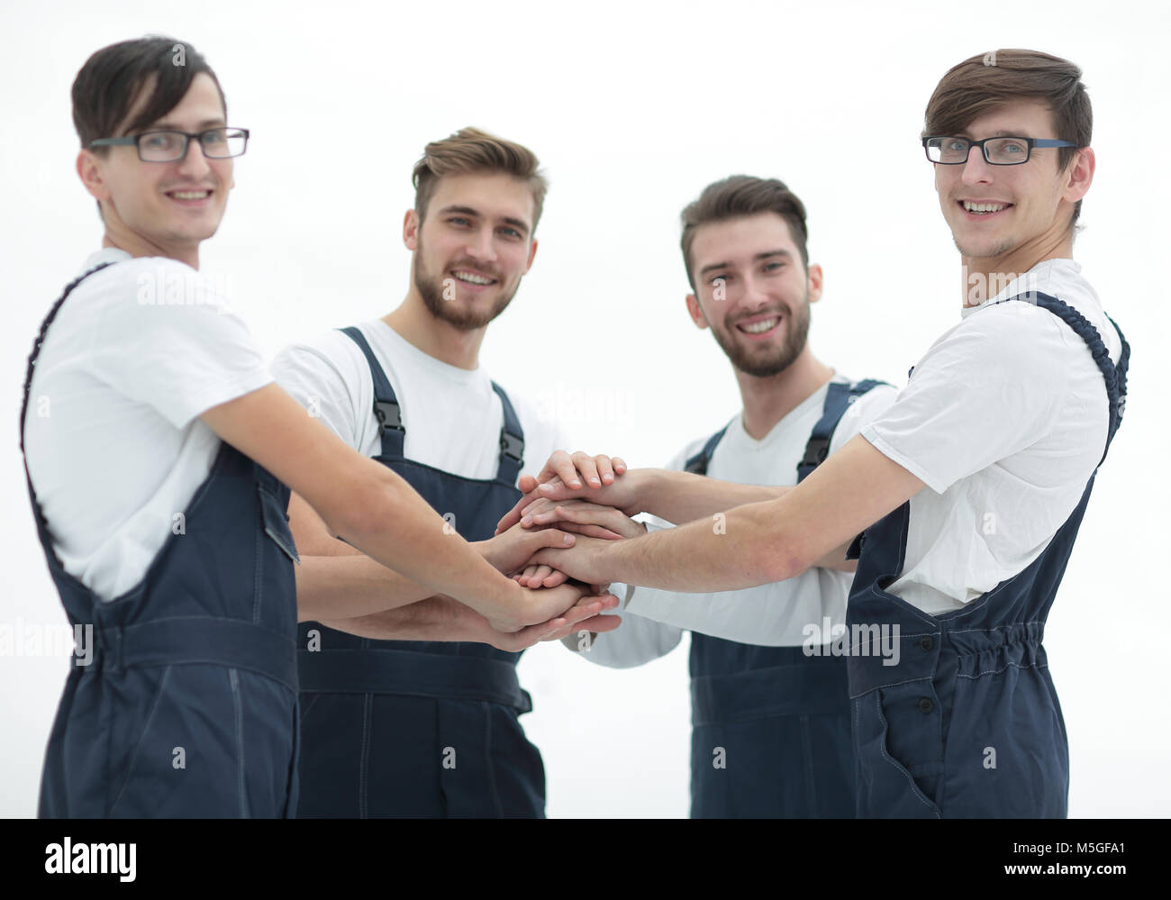 Team of movers joining hands Stock Photo - Alamy