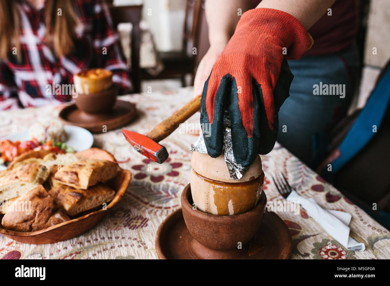 The national Turkish dish in the pot that is broken before use is called Testi-kebab. The cook breaks the pot with a hammer before serving the restaurant visitor. Stock Photo