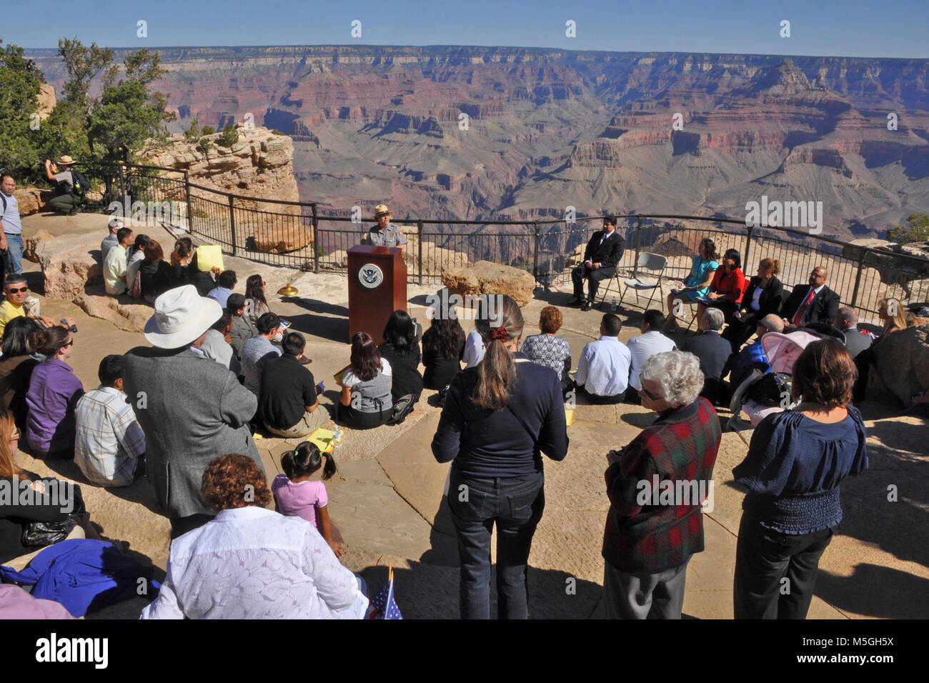 Naturalization Ceremony Grand Canyon mq  On Thursday, September 23, Grand Canyon National Park in coordination with The Department of Homeland Security, hosted a naturalization ceremony at the Mather Amphitheatre on the South Rim. This is the first time in history that Grand Canyon National Park has hosted such an event.   Under blue skies and before a breathtaking view, 23 individuals from 12 different countries including, Colombia, Dominican Republic, Guatemala, Japan, Mexico, Morocco, Australia, Trinidad and Tobago, Uruguay, Venezuela, Vietnam and Zambia, became naturalized citizens. Many f Stock Photo