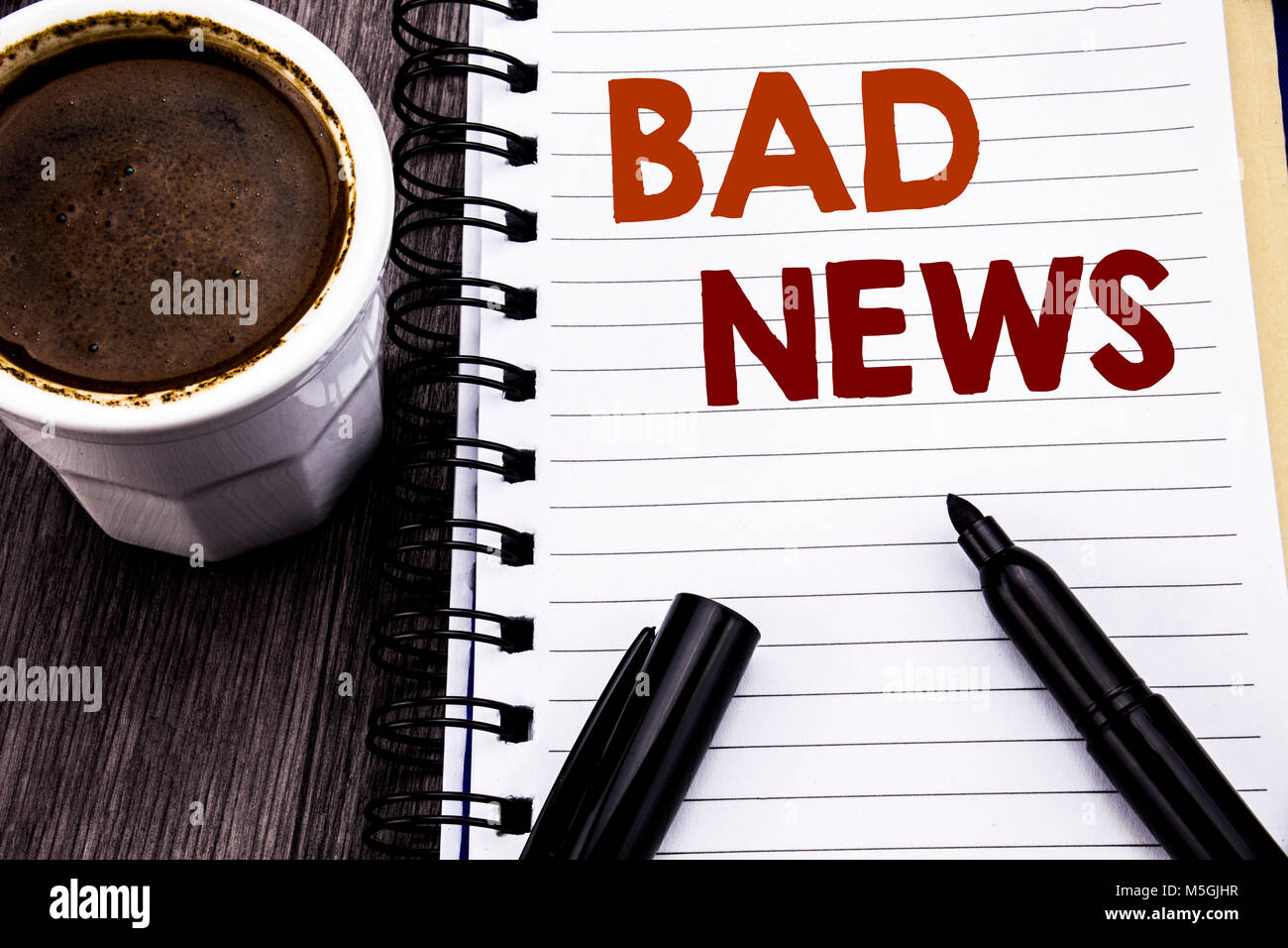 Writing text showing Bad News. Business concept for Failure Media Newspaper written on notebook book note paper on wooden wood background. With coffee Stock Photo
