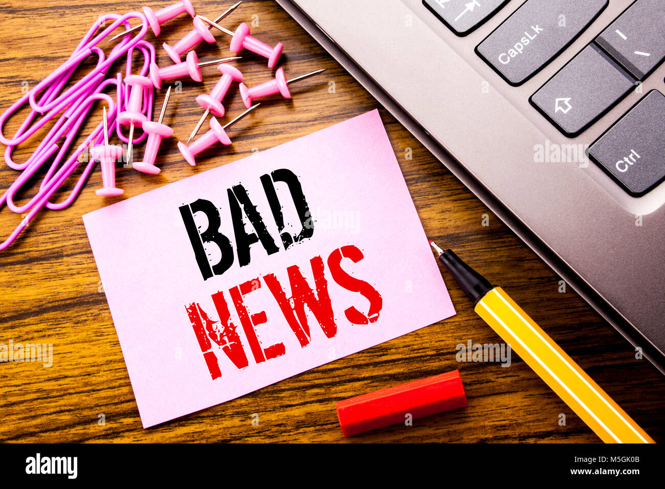 Handwritten text showing Bad News. Business concept for Failure Media Newspaper written on pink sticky note paper on wooden background next to keyboar Stock Photo