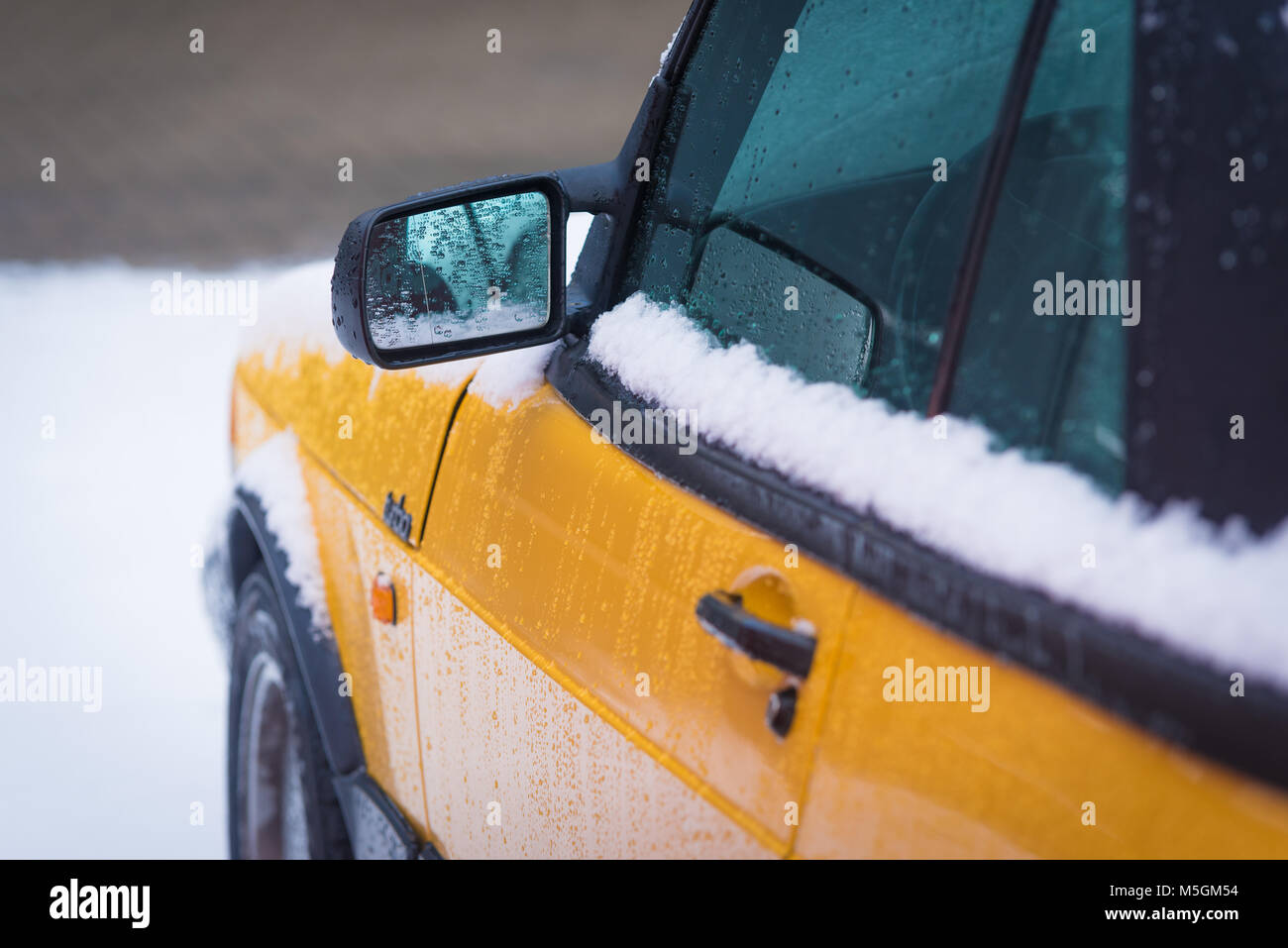 OLDENZAAL, NETHERLANDS - JANUARY 15, 2017: Detail of a yellow vintage Saab 900 turbo S convertible in snowy conditions. Stock Photo