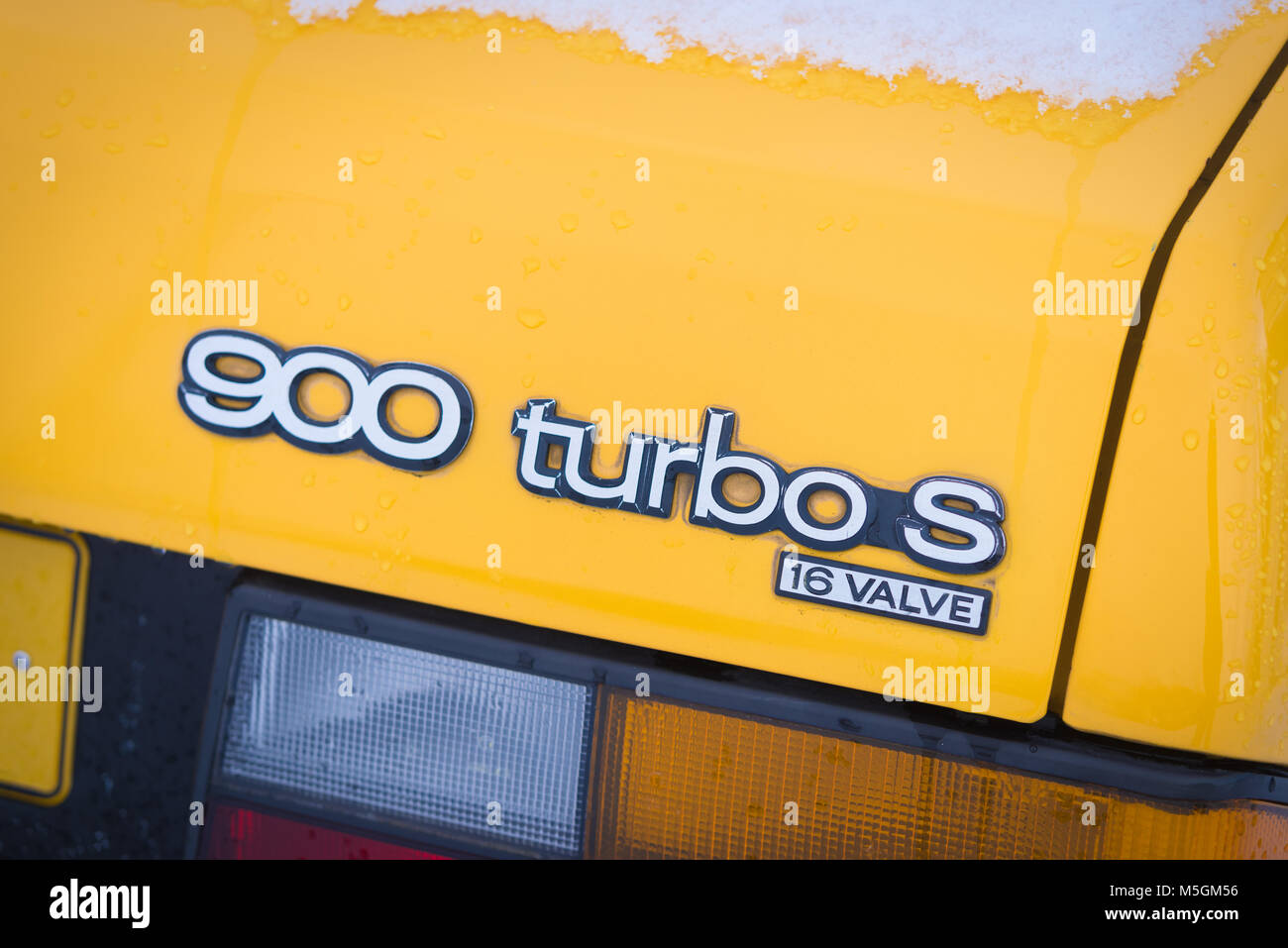 OLDENZAAL, NETHERLANDS - JANUARY 15, 2017: Detail of a yellow vintage Saab 900 turbo S convertible in snowy conditions. Stock Photo