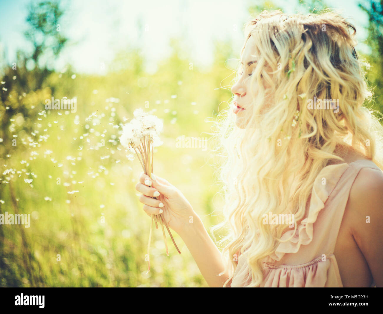 Outdoor fashion portrait of romantic blonde with dandelions Stock Photo