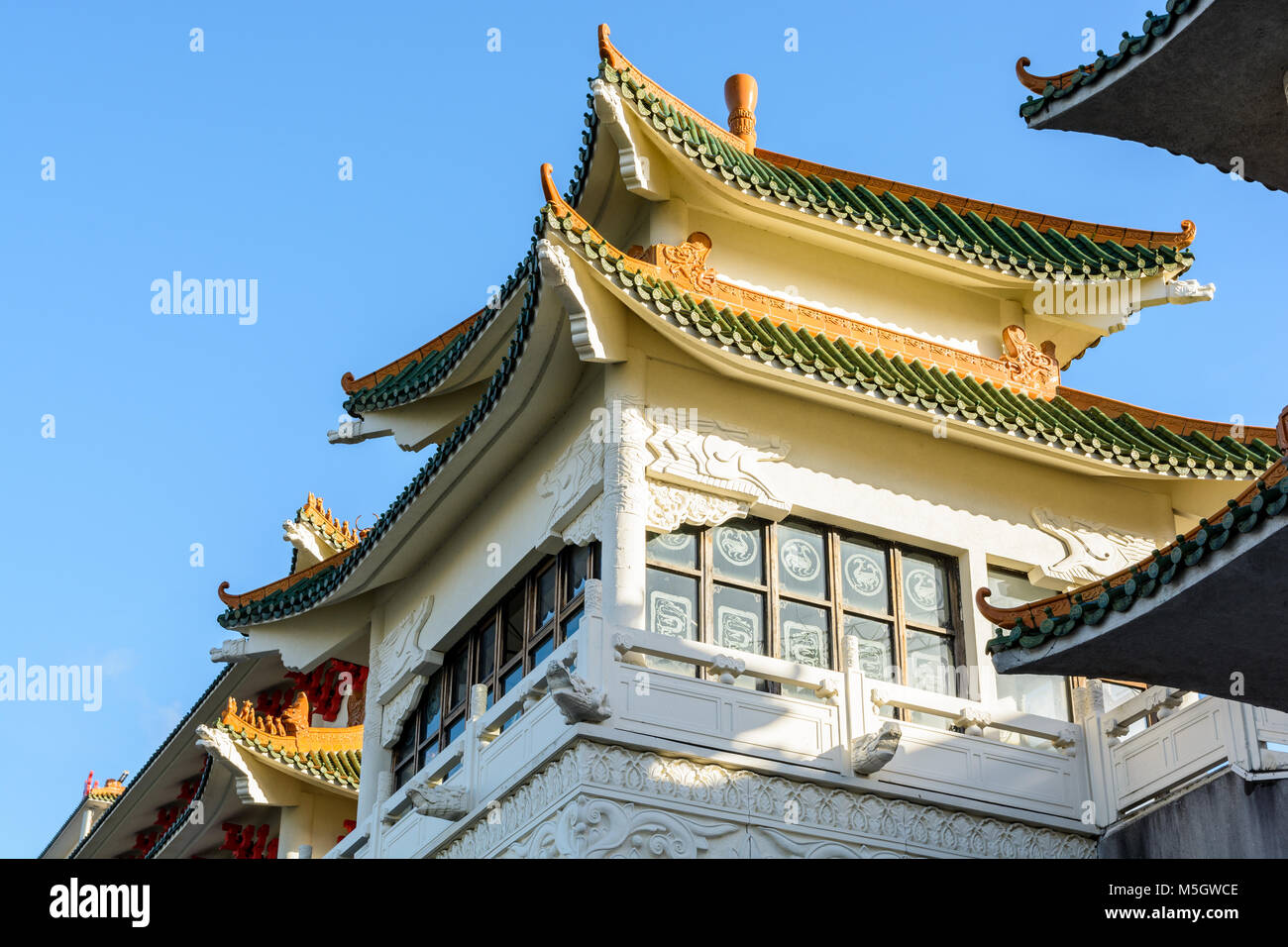 View of the chinese-inspired architecture of the Huatian Chinagora hotel complex with curved roof corners and traditional glazed roof tiles. Stock Photo