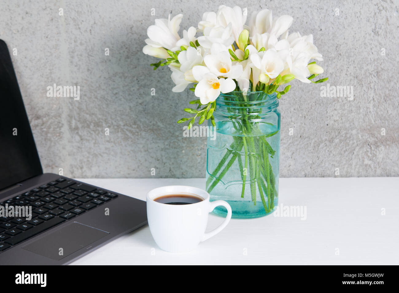 contemporary desk top with computer, flowers and a cup of coffee Stock Photo