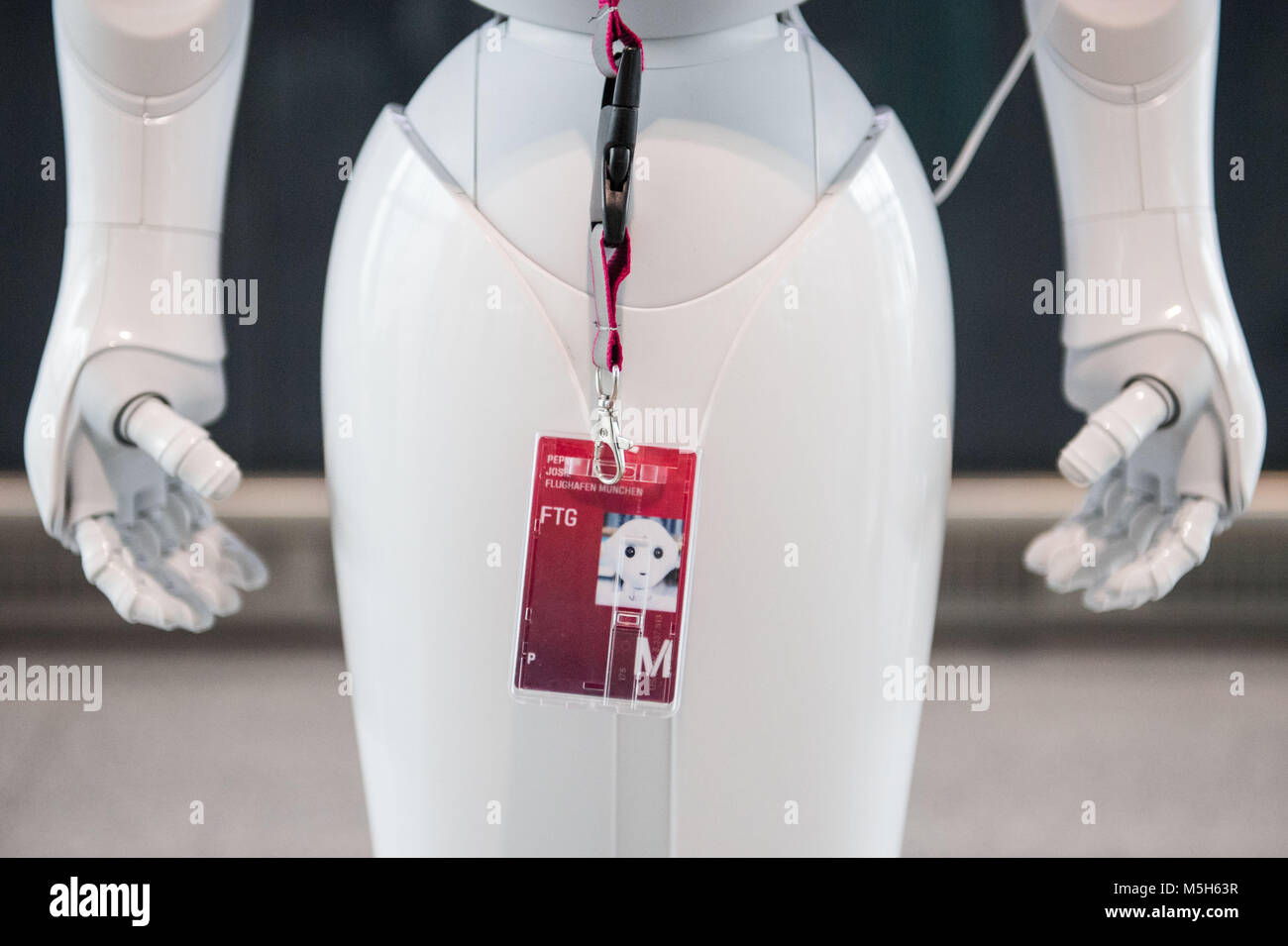 Munich, Germany. 20th Feb, 2018. A staff card dangles around the neck of robot Josie Pepper, who assists passengers travelling from the airport in Munich, Germany, 20 February 2018. Pepper is a humanoid robot programmed to analyse and emulate human gestures and facial expressions. Credit: Lino Mirgeler/dpa/Alamy Live News Stock Photo