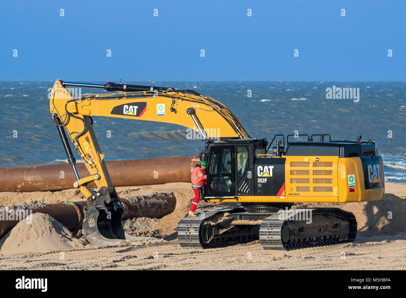 Caterpillar 352F XE, hydraulic excavator used by Dredging International / DEME for sand replenishment / beach nourishment along the North Sea coast Stock Photo