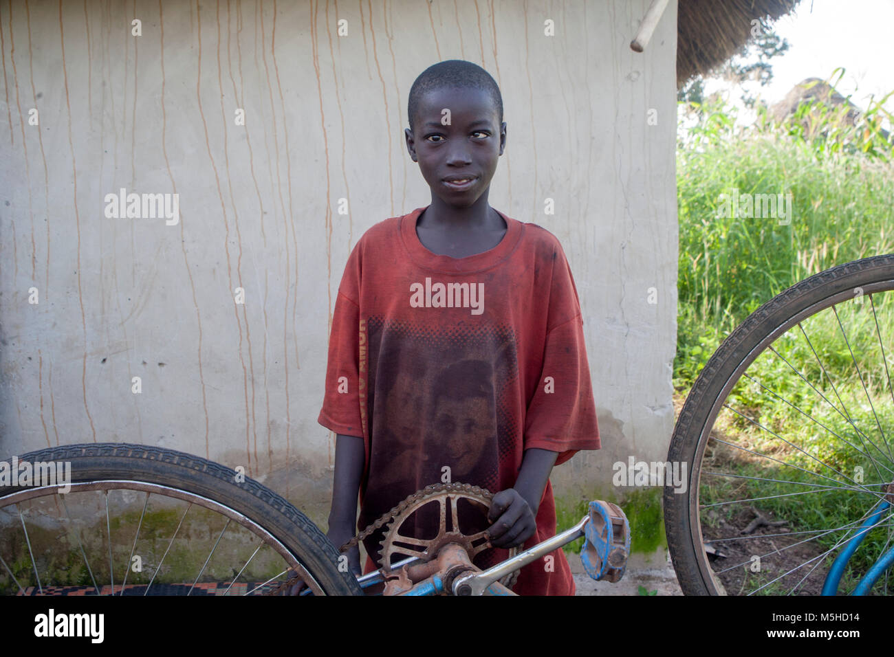 Boy from the village of Kedougou in Senegal with his bicycle Stock Photo
