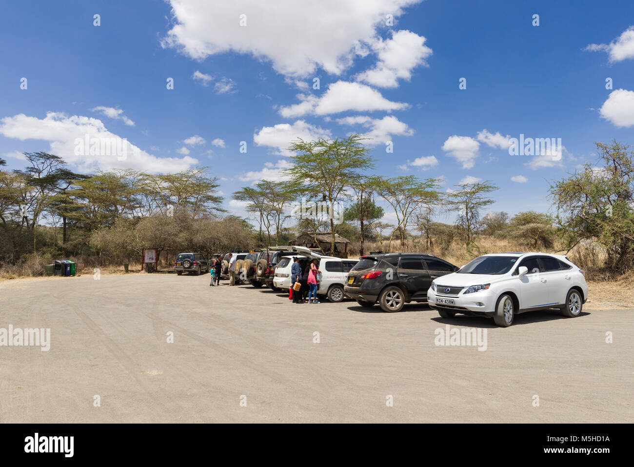 Vehicles parked at the Hippo pools car park in Nairobi National Park with people standing by the cars, Kenya Stock Photo