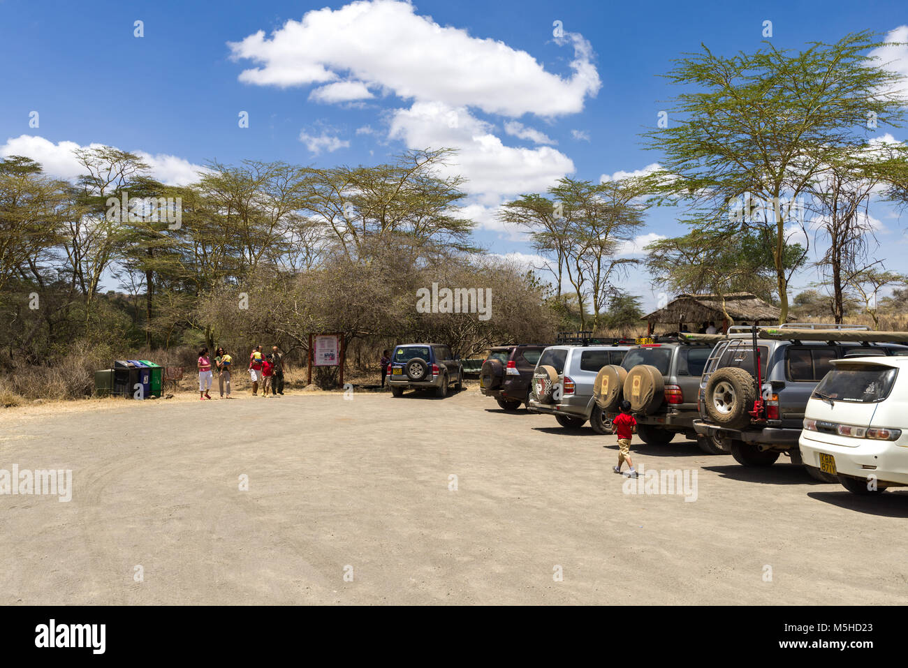 Vehicles parked at the Hippo pools car park in Nairobi National Park with people standing by the cars, Kenya Stock Photo