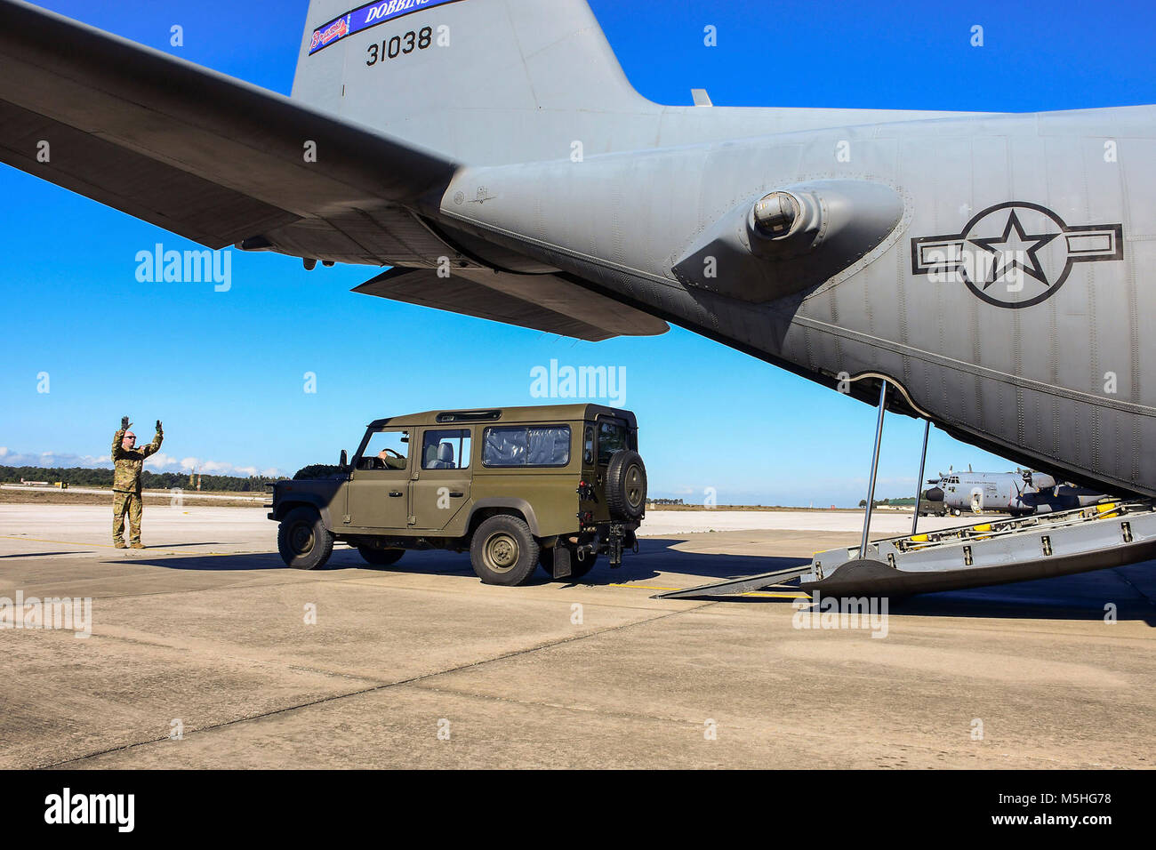 Tech. Sgt. Michael Hoffman, a 700th Airlift Squadron loadmaster, guides a vehicle into the back of a C-130H3 Hercules on the flightline at Monte Real Air Base, Portugal, on Feb. 5, 2018. Loadmasters on the plane worked quickly to secure the vehicle before taking off and heading to the landing zone where they offloaded the vehicle driven by Portuguese navy special forces as part of Real Thaw 18, a Portuguese-led exercise involving several NATO countries working together to perform realistic tasks both in the air and on the ground. (U.S. Air Force Stock Photo