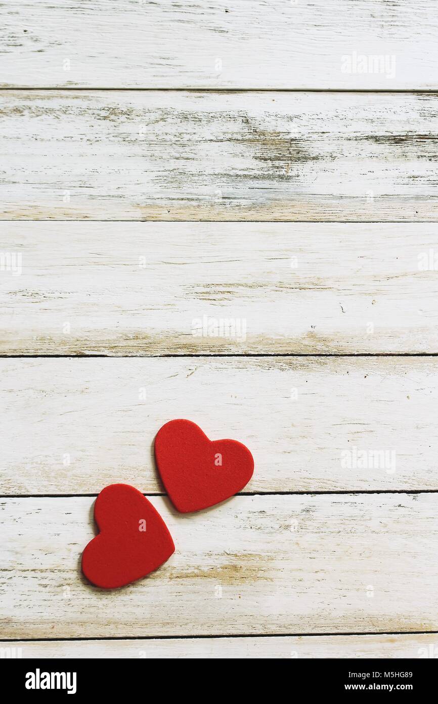 Two red hearts on white wooden background / Valentines day card with ...