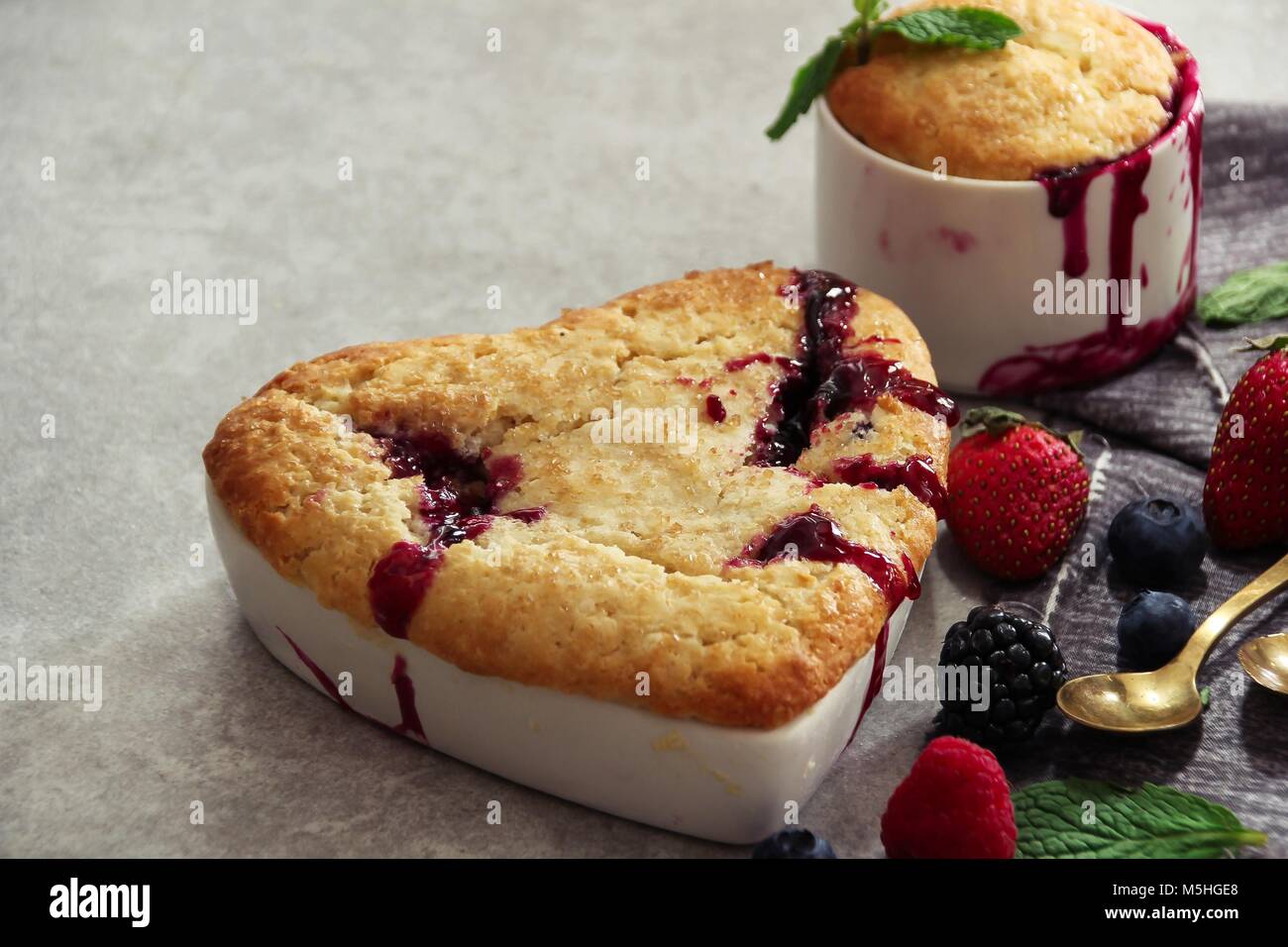 Mixed Berry Cobbler in heart shaped Ramekin / Valentines day dessert, selective focus Stock Photo