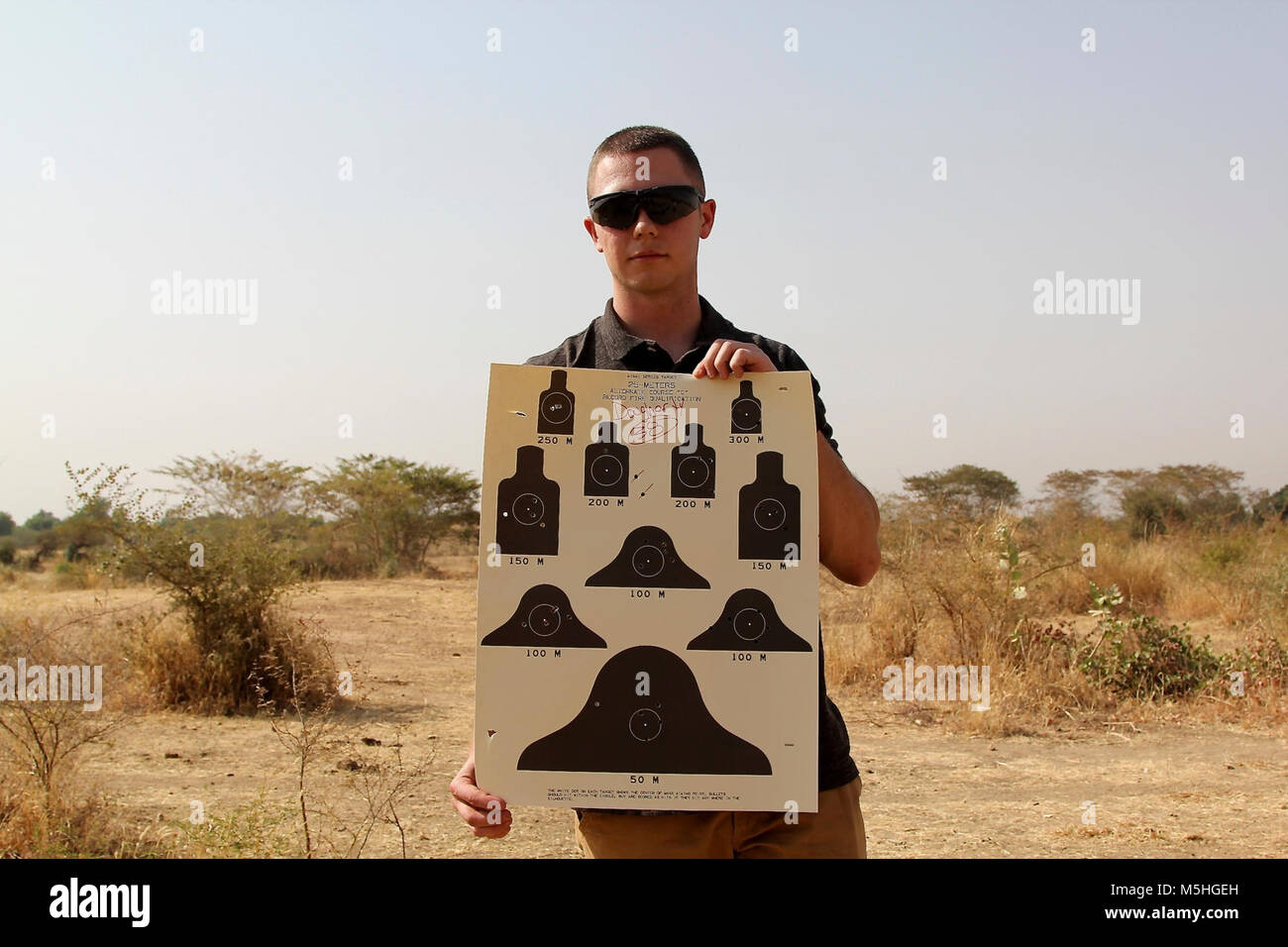Soldiers of Task Force Darby and 1st Battalion, 87 Infantry Regiment, 1st Brigade Combat Team, 10th Mountain Division, qualify on a weapon’s range in Garoua, Cameroon Feb. 8, 2018. Pfc. Daugherty shows his M4 range card. TF Darby serve members are serving in a support role for the Cameroonian Military’s fight against the violent extremist organization Boko Haram. Stock Photo
