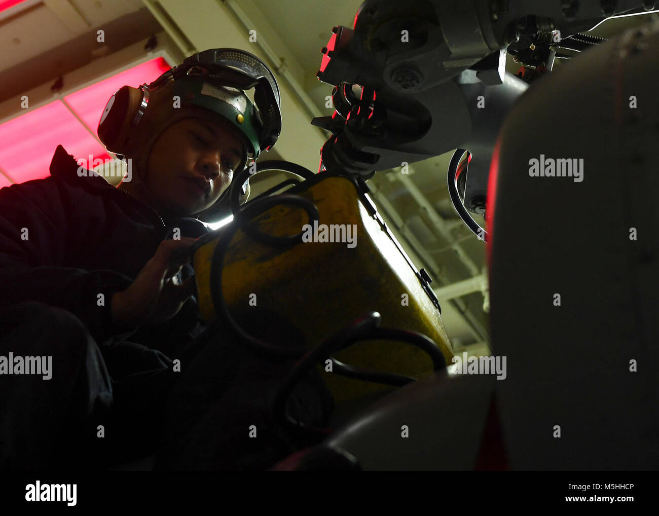 PACIFIC OCEAN (Feb. 12, 2018) Aviation Structural Mechanic 2nd Class Benjamin Mones, from San Diego, conducts maintenance on an MH-60R Sea Hawk, assigned to the “Scorpions” of Helicopter Maritime Strike Squadron (HSM) 49, aboard the Arleigh Burke-class guided-missile destroyer USS Sterett (DDG 104). Sterett is on a scheduled deployment to conduct operations in the Indo-Pacific region. It will also support the Wasp Expeditionary Strike Group (ESG) in order to advance U.S. Pacific Fleet’s Up-Gunned ESG concept and will train with forward-deployed amphibious ships across all mission areas. (U.S.  Stock Photo