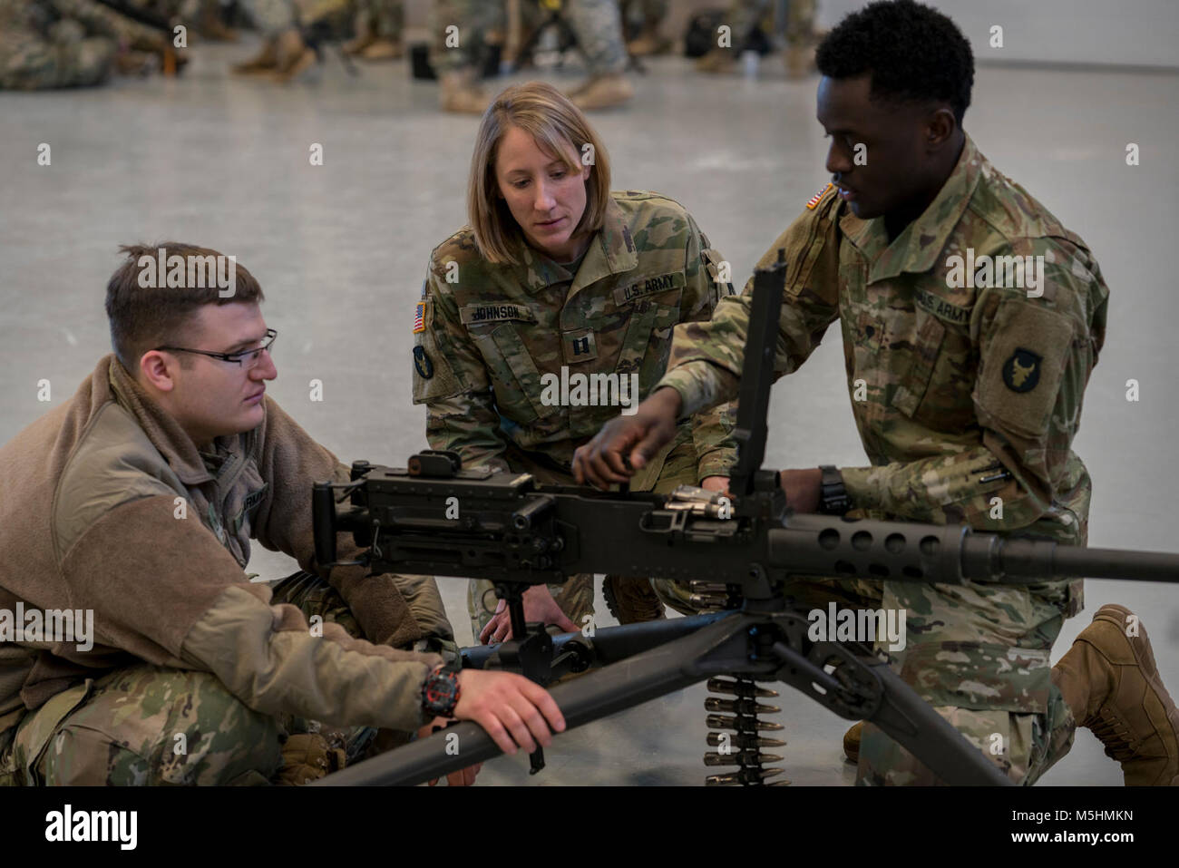 Capt. Janelle Johnson (center), commander of A Co., 134th Brigade Support Battalion, listens to Pfc. Bryan Christenson (left) and Spc. Mainza Malambo (right), both petroleum supply specialists with A Co., 134th BSB, explain how to qualify on the M2 .50-caliber machine gun during weapons training on Feb. 11, 2018, in Arden Hills, Minn. A unique quality about Johnson is that she can relate to Soldiers at every level because she has trained as an enlisted Soldier and a warrent officer before becoming a commissioned officer. (Minnesota National Guard Stock Photo