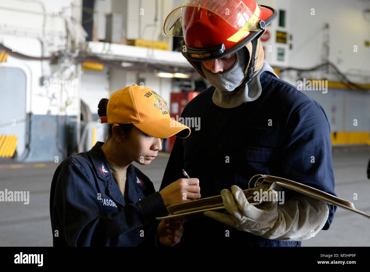 SAN DIEGO (Feb. 9, 2018) Electrician’s Mate 2nd Class Therese Sanpascual, a damage control training team member, trains Electrician's Mate Fireman Clayton Saving in the hangar bay aboard amphibious assault ship USS Boxer (LHD 4) during a general quarters drill. Boxer is currently in its homeport preparing for contractor sea trials. (U.S. Navy Stock Photo