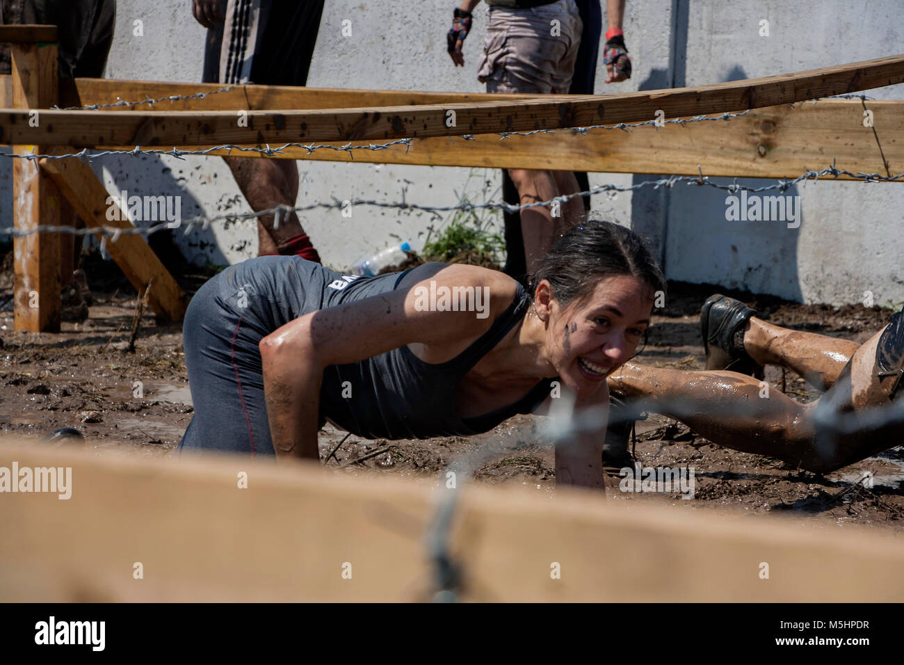 A woman crawling under barbed wire during strength race Legion Run held in Sofia, Bulgaria on 26 July 2014 Stock Photo