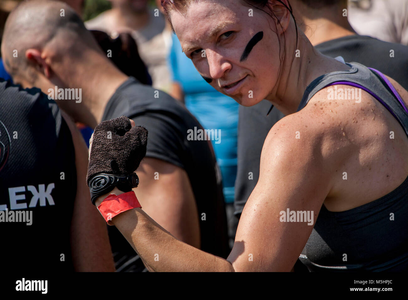 A woman is showing her muscles during physical competition Legion Run held in Sofia, Bulgaria on 26 July 2014 Stock Photo