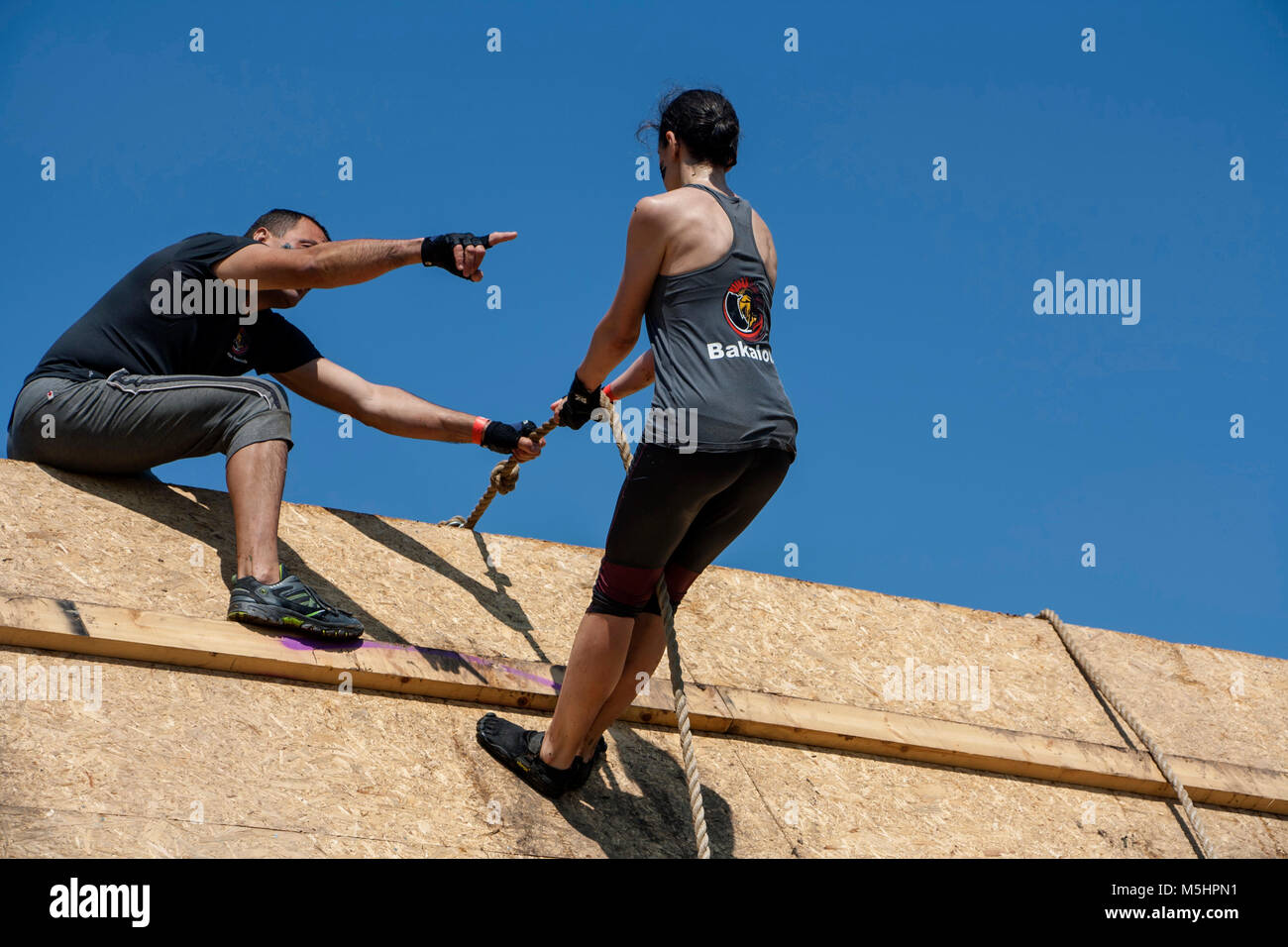 A men is helping a woman at a strength race Legion Run held in Sofia, Bulgaria on 26 July 2014 Stock Photo
