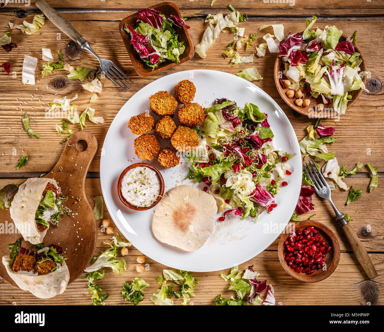 Plate of traditional falafel patties with lettuce, sauce and pita Stock Photo