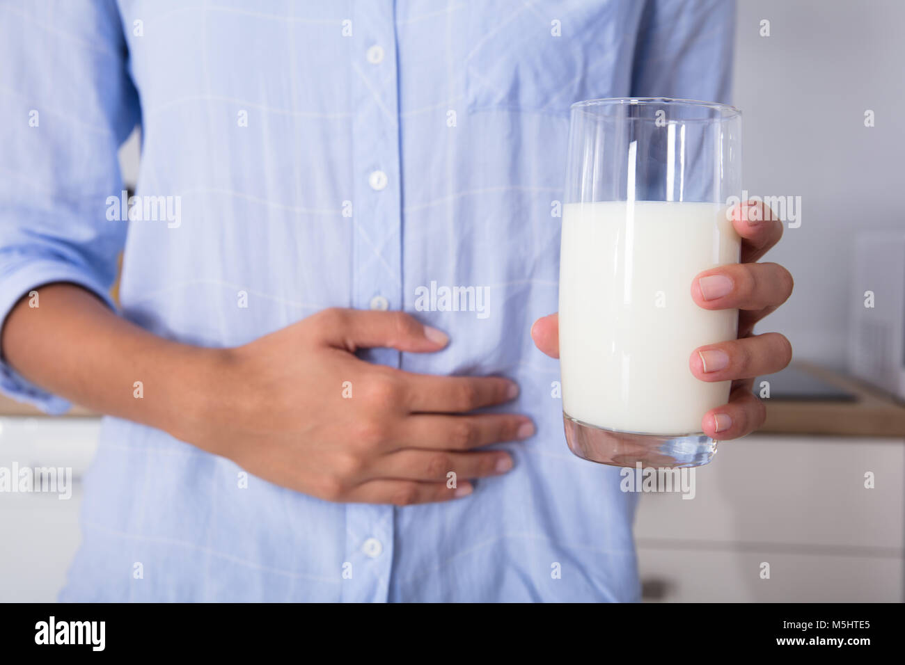 Mid Section View Of A Woman With Stomach Pain Holding Glass Of Milk